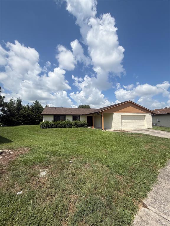 A single-story house with a beige brick facade, a brown roof, and a two-car garage — 10719 LAZY LAKE DRIVE, ORLANDO, FL