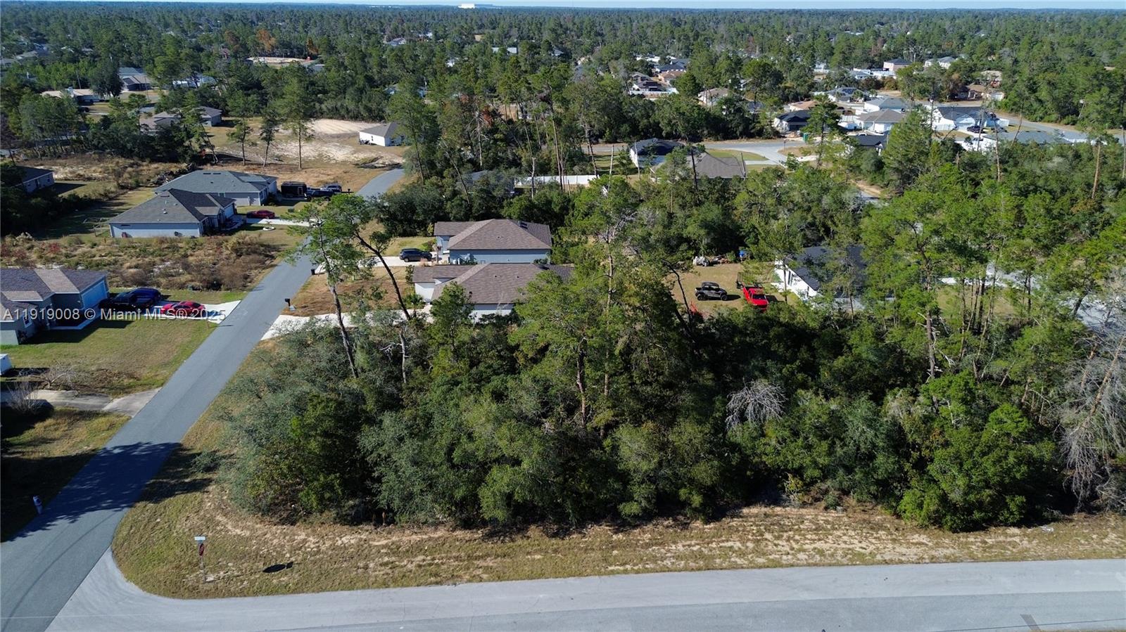 An aerial view shows a wooded residential lot situated between paved roads and existing houses — 0 SW 167th Loop, Ocala FL 34473, OCALA, FL