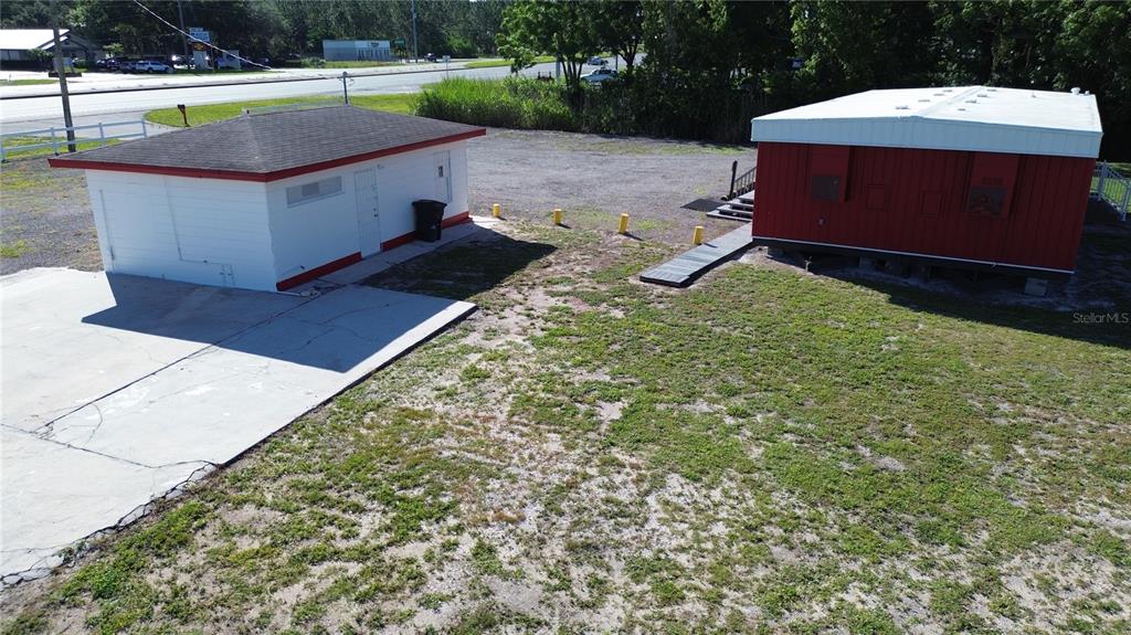 An aerial view shows a small white building and a red modular structure on a lot — 4109 US HIGHWAY 27 S, SEBRING, FL