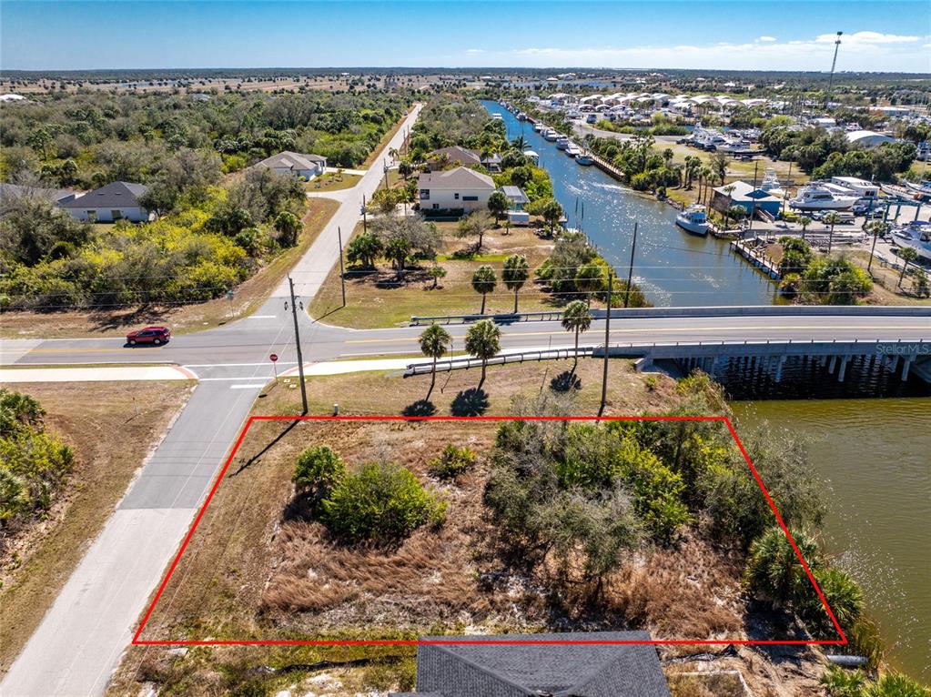 An aerial view shows a vacant, rectangular lot bordered by a road and a canal — 10311 REDONDO STREET, PORT CHARLOTTE, FL