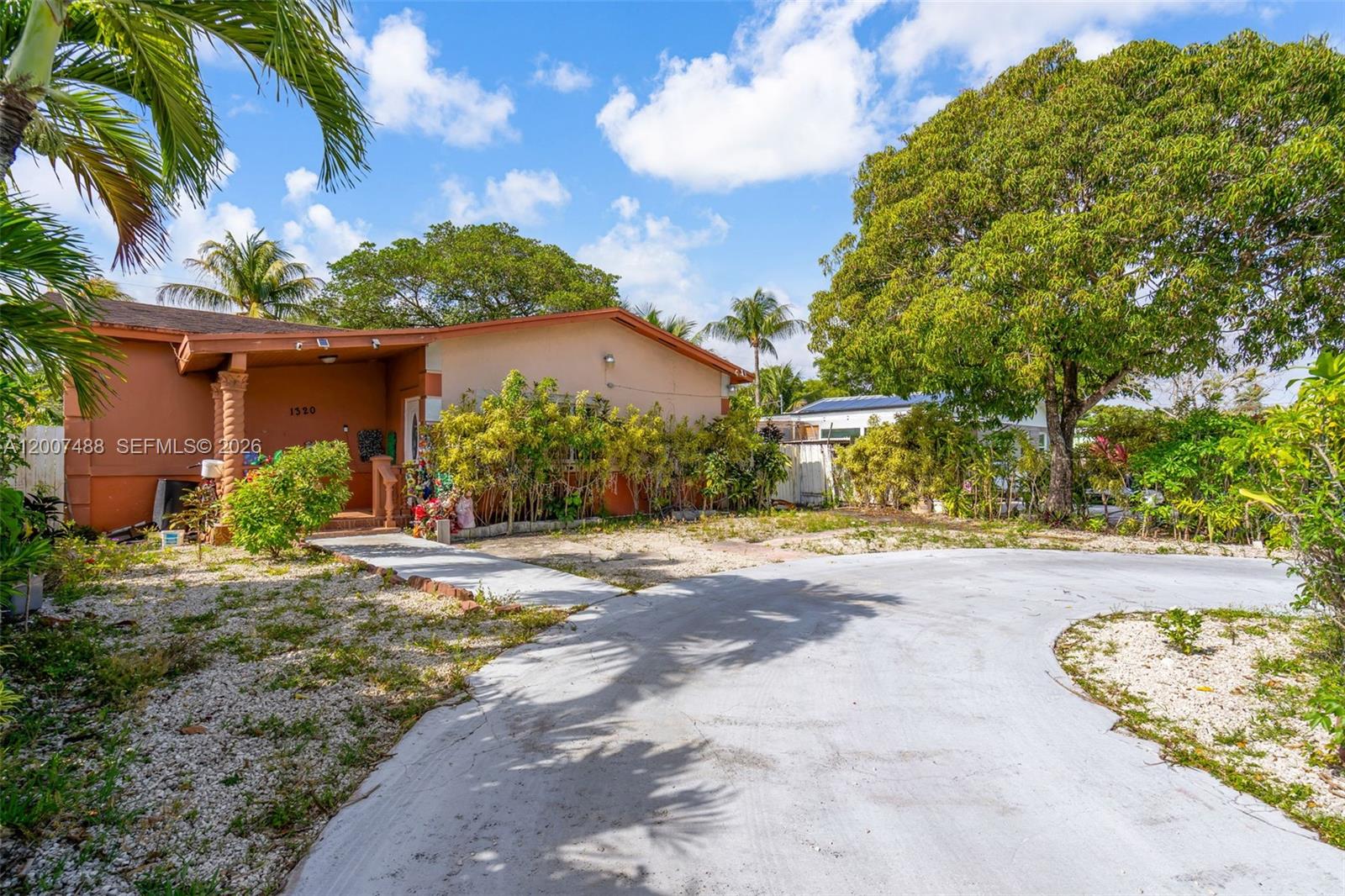 A single-story house with a curved concrete driveway and a large tree in the yard — 1320 NE 135th St, North Miami FL 33161, NORTH MIAMI, FL