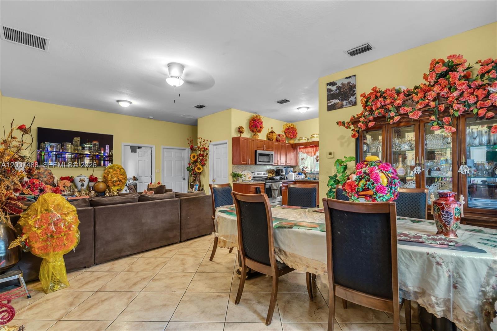A dining area with a table and chairs opens into a kitchen and living room — 1320 NE 135th St, North Miami FL 33161, NORTH MIAMI, FL