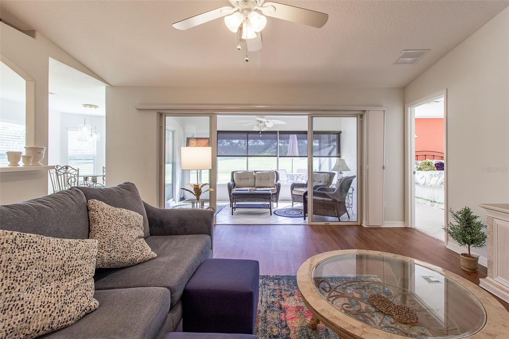 A living room features a gray sofa, glass coffee table, and sliding doors to a lanai — 15691 SW 11TH COURT ROAD, OCALA, FL