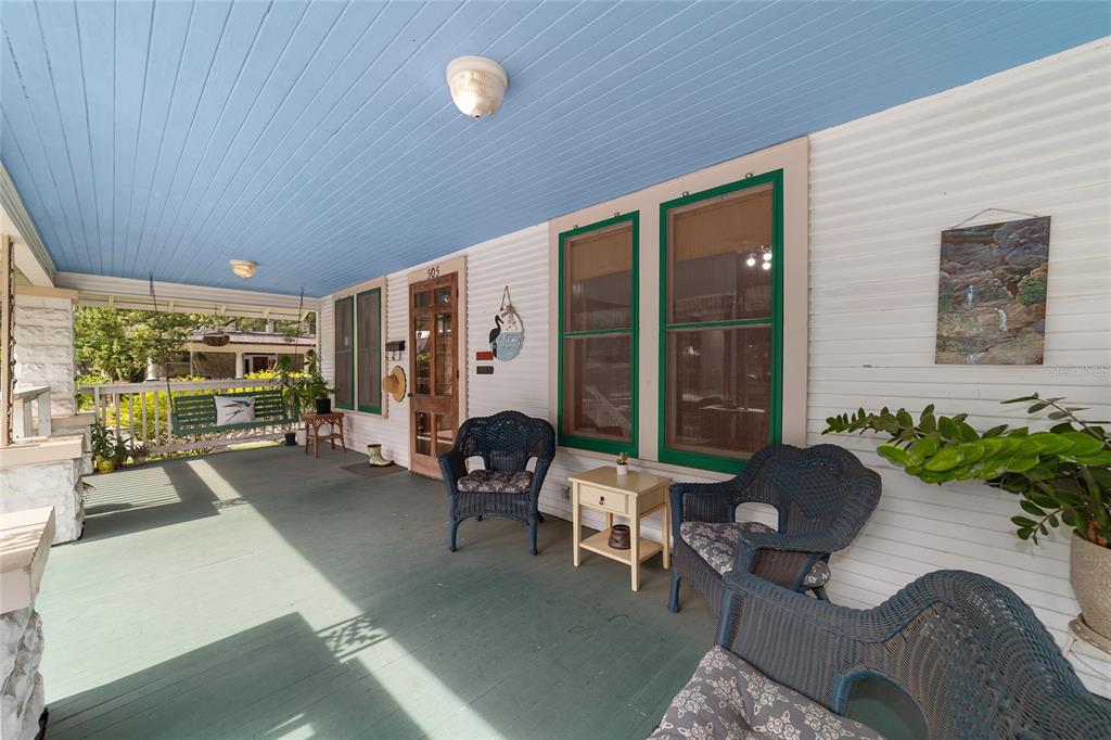 A covered front porch features a blue ceiling, green floor, and several wicker chairs — 505 SE SANCHEZ AVENUE, OCALA, FL