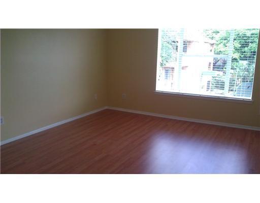 An empty room with yellow walls, wood-look flooring, and a large window with blinds — 1845 Palm Cove Boulevard # 301, Delray Beach FL 33445, DELRAY BEACH, FL