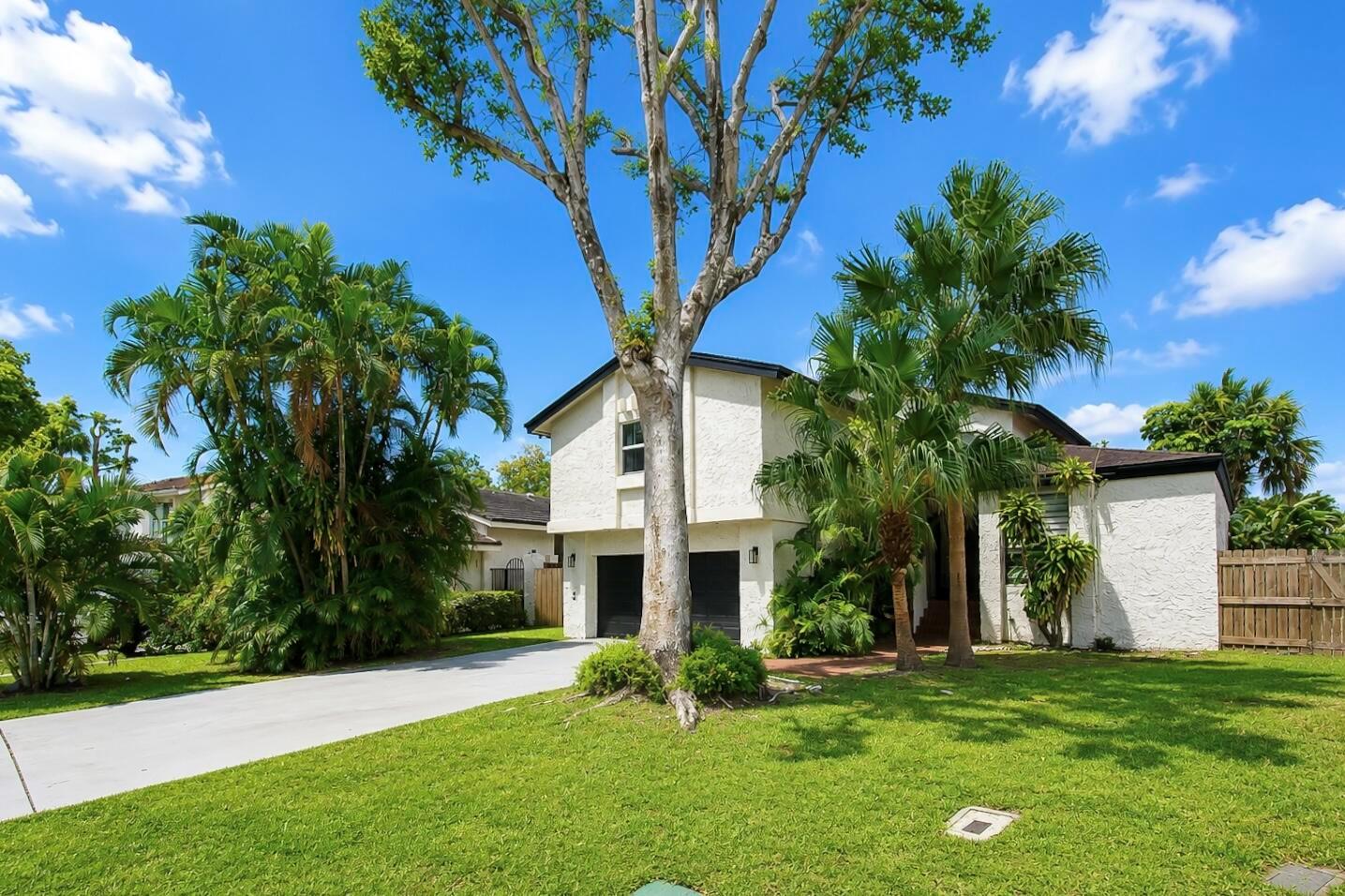 A two-story white house with a two-car garage, palm trees, and a large front lawn — 6458 Pond Apple Road, Boca Raton FL 33433, BOCA RATON, FL