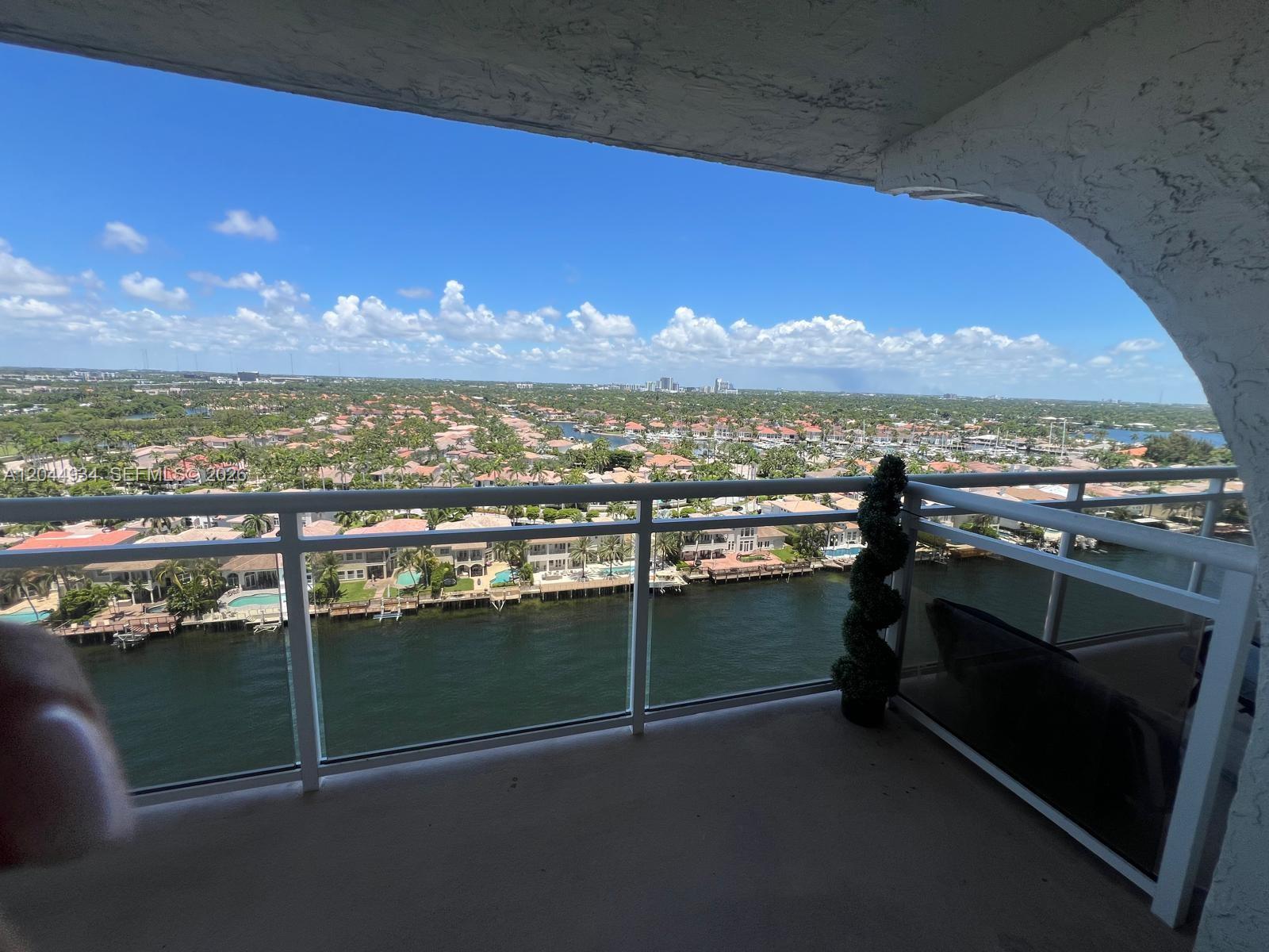 A balcony with a glass railing overlooks a canal and a residential neighborhood — 1600 S Ocean Dr # 18C, Hollywood FL 33019, HOLLYWOOD, FL