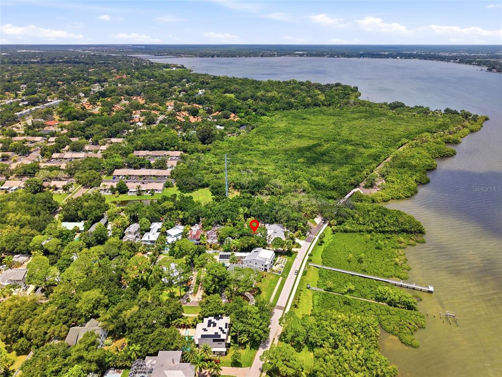 An aerial view shows a waterfront property with a dock and surrounding lush vegetation — Lot 14 E MARSHALL STREET, SAFETY HARBOR, FL