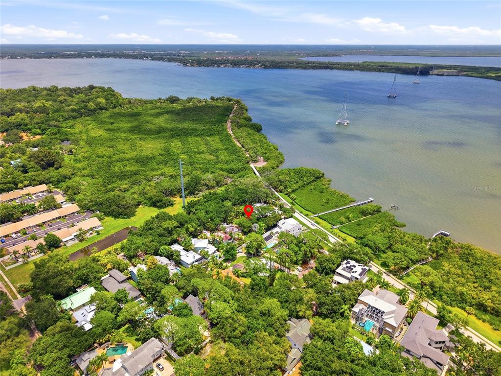 An aerial view shows a residential neighborhood nestled among trees along a large body of water — Lot 14 E MARSHALL STREET, SAFETY HARBOR, FL