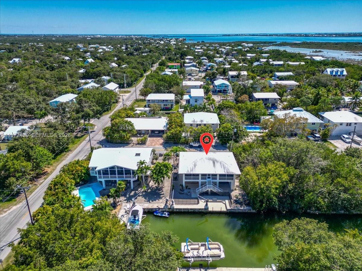 An aerial view shows a waterfront house with a pool and boat dock — 29051 Magnolia Ln, Big Pine FL 33043, BIG PINE, FL