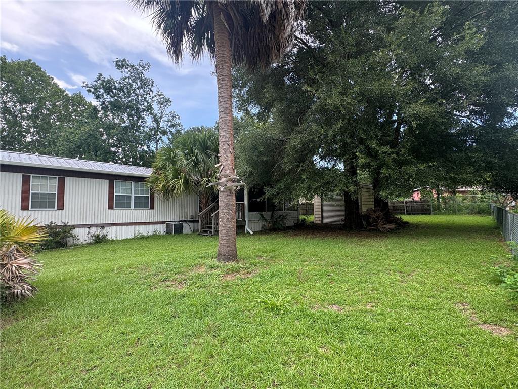 A side view of a mobile home with a palm tree and a shed — 3285 SE 131ST PLACE, BELLEVIEW, FL