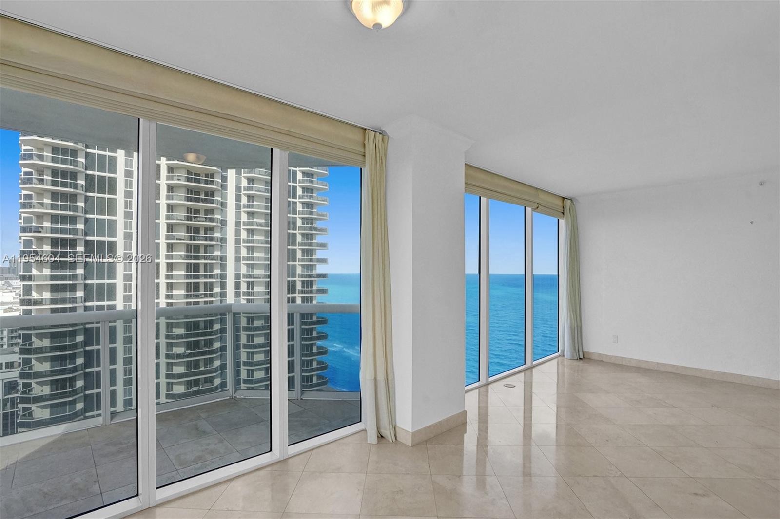 An elevated view shows a waterway, residential buildings, and a distant city skyline — 4775 Collins Ave # 3007, Miami Beach FL 33140, MIAMI BEACH, FL