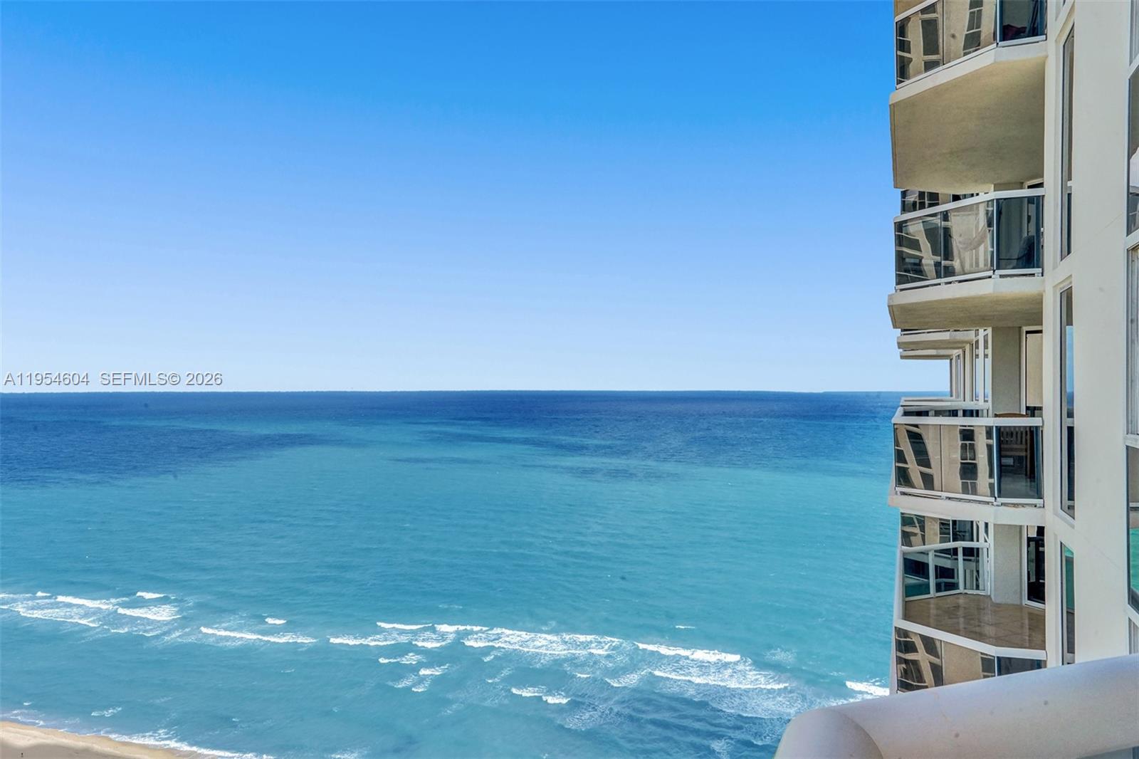 An elevated view shows a waterway, luxury yachts, coastal homes, and a high-rise building — 4775 Collins Ave # 3007, Miami Beach FL 33140, MIAMI BEACH, FL