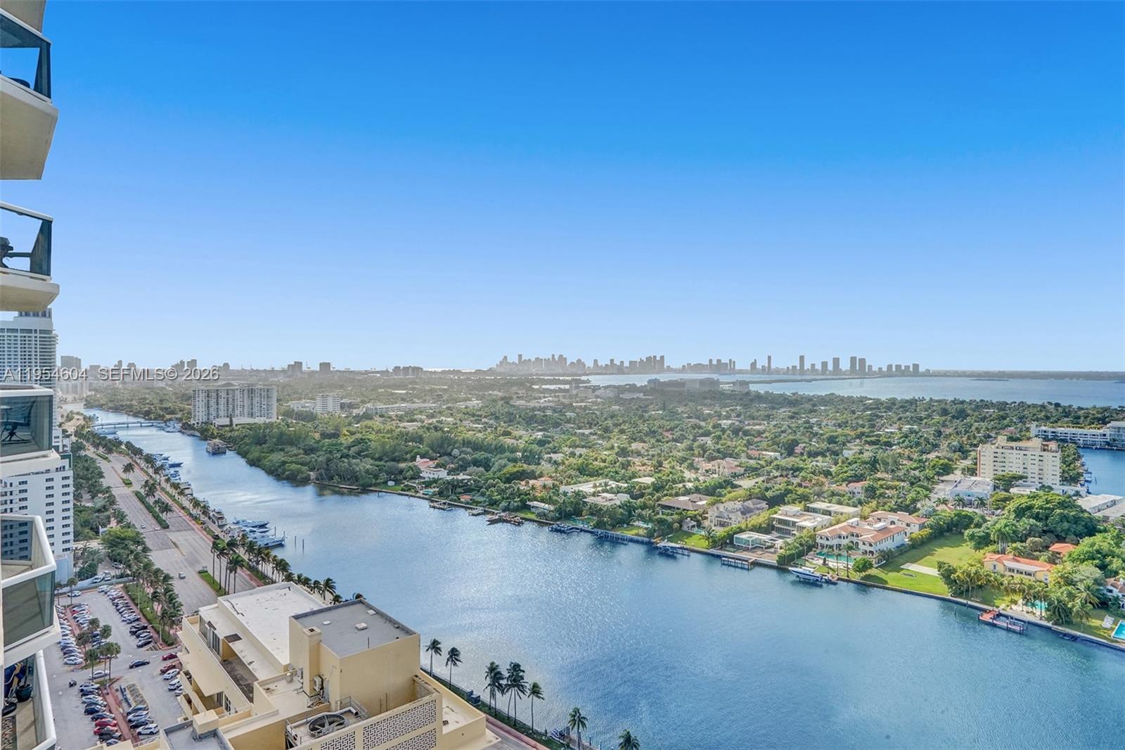 An empty living area features light tile floors, white walls, and floor-to-ceiling windows overlooking water — 4775 Collins Ave # 3007, Miami Beach FL 33140, MIAMI BEACH, FL