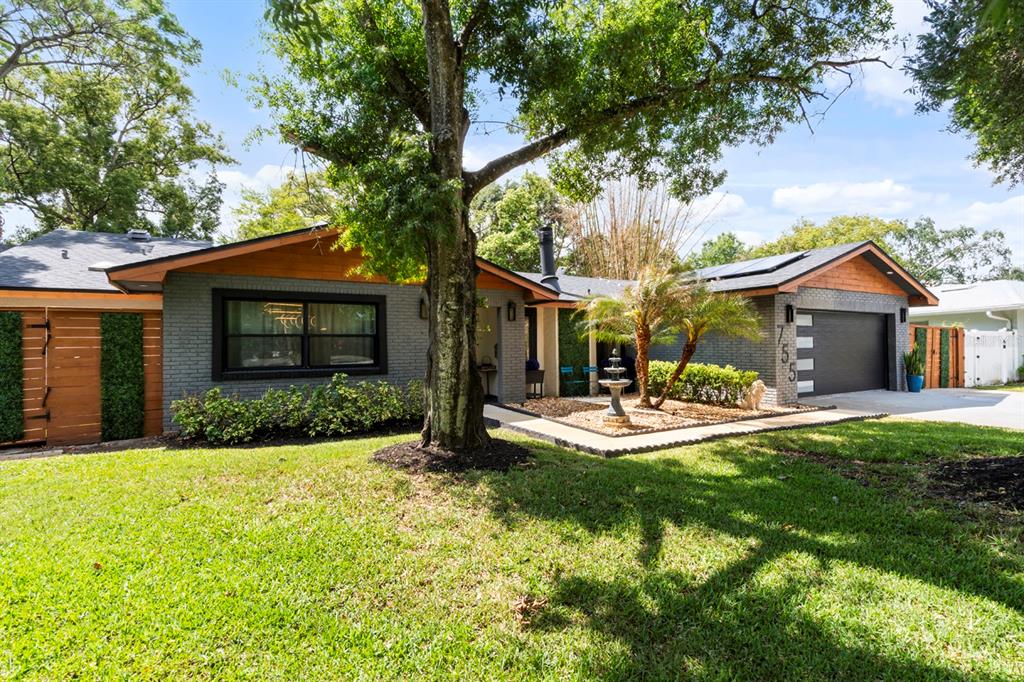 A single-story gray brick house with wood accents, a garage, and a large front tree — 755 WOODSIDE ROAD, MAITLAND, FL