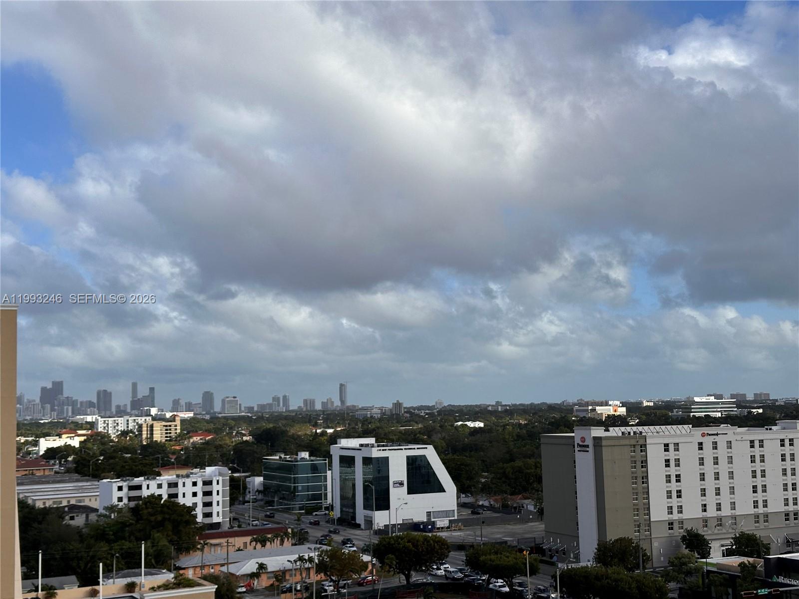 An elevated view of a city skyline with buildings, trees, and a cloudy sky — 4242 NW 2nd St # 1116, Miami FL 33126, MIAMI, FL