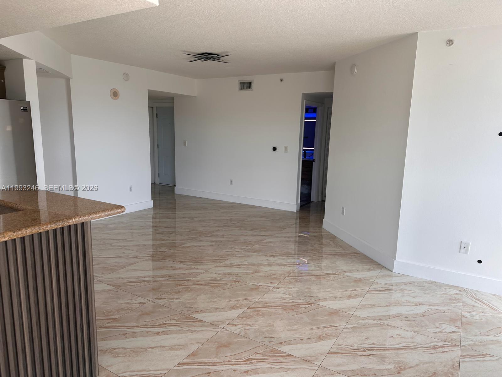 An open-concept living area features polished marble-look tile flooring and white walls — 4242 NW 2nd St # 1116, Miami FL 33126, MIAMI, FL