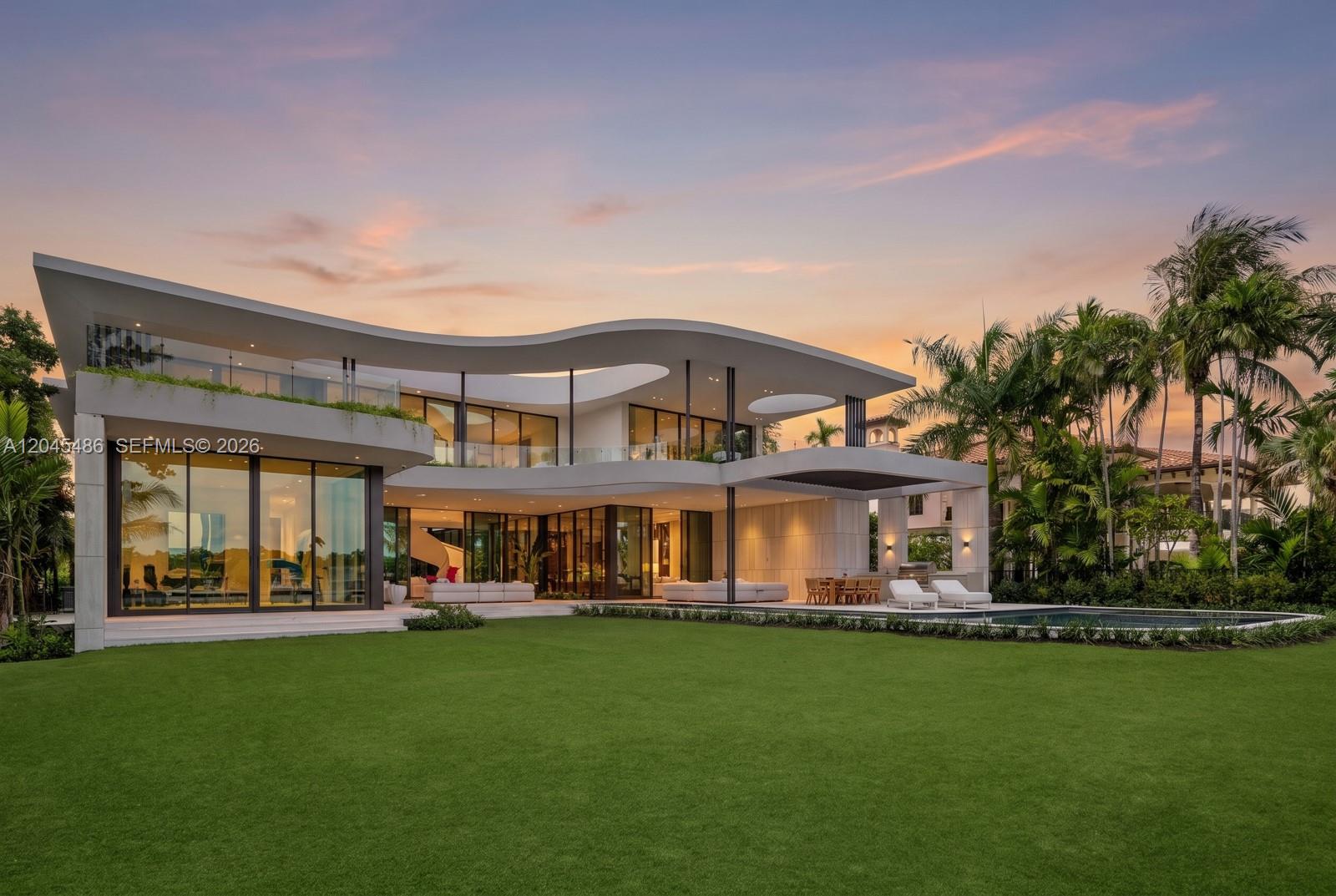A modern two-story house with a curved roof, glass walls, and a backyard swimming pool — 1015 S Southlake Dr, Hollywood FL 33019, HOLLYWOOD, FL