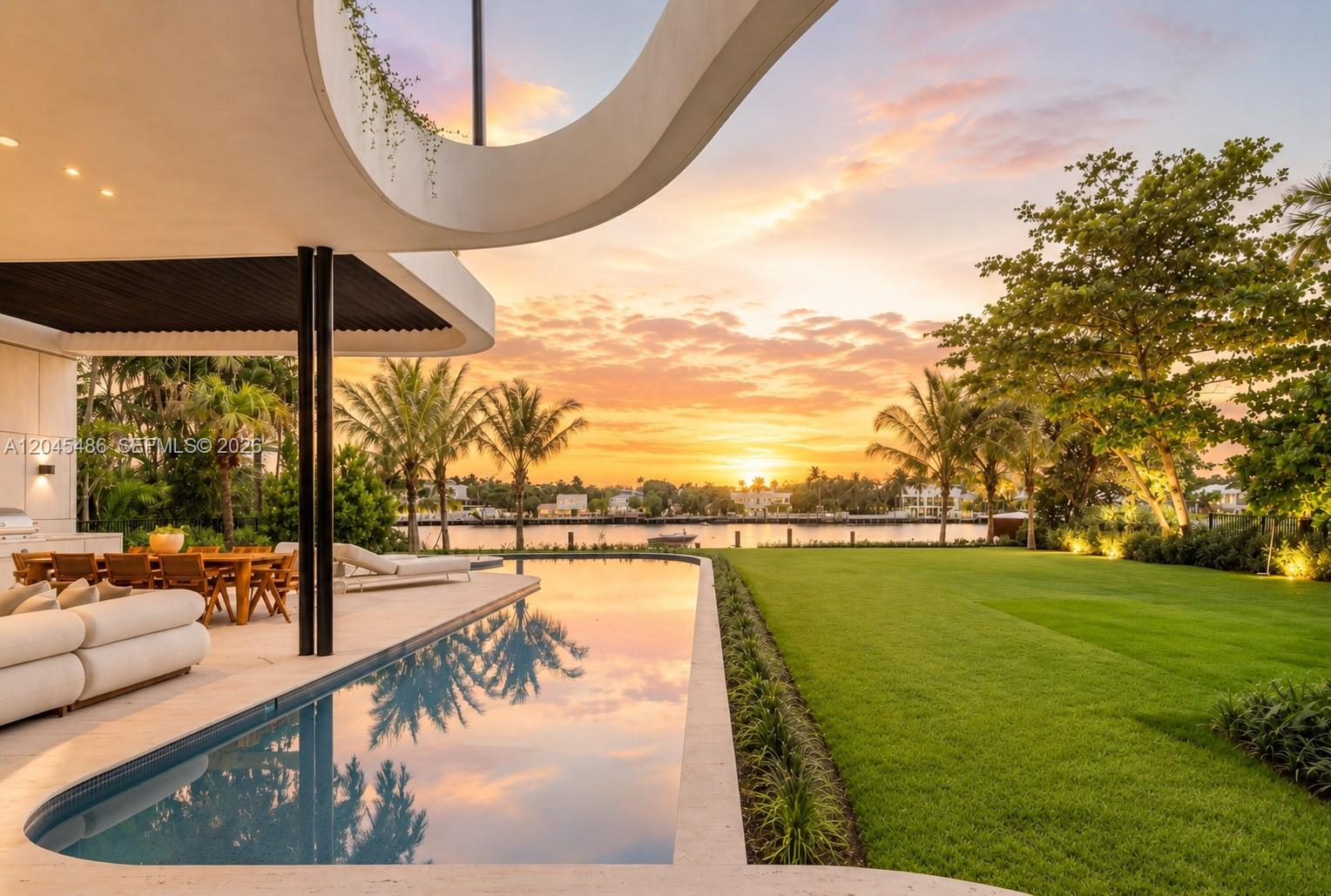 A modern home features a curved roofline, an infinity pool, and a lawn overlooking water — 1015 S Southlake Dr, Hollywood FL 33019, HOLLYWOOD, FL