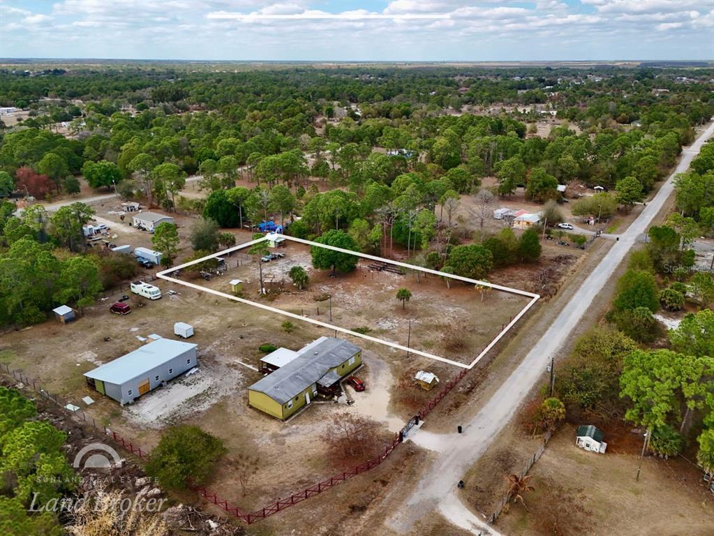 An aerial view shows a fenced rectangular lot with a house and outbuildings nearby — 220 N PALOMINO STREET, CLEWISTON, FL