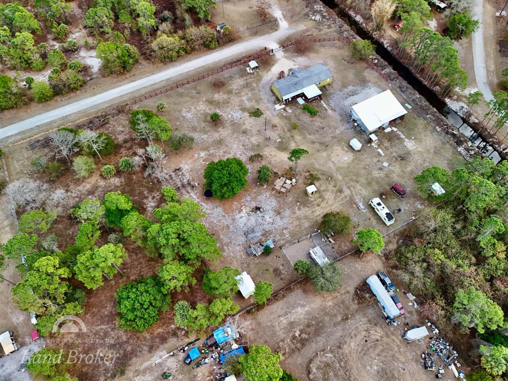 An aerial view shows a rural property with a house, outbuildings, and scattered trees — 220 N PALOMINO STREET, CLEWISTON, FL