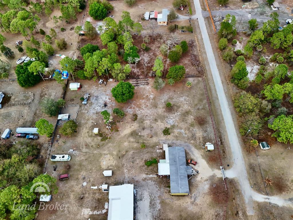 An aerial view shows a rural property with a house, outbuildings, and scattered trees — 220 N PALOMINO STREET, CLEWISTON, FL