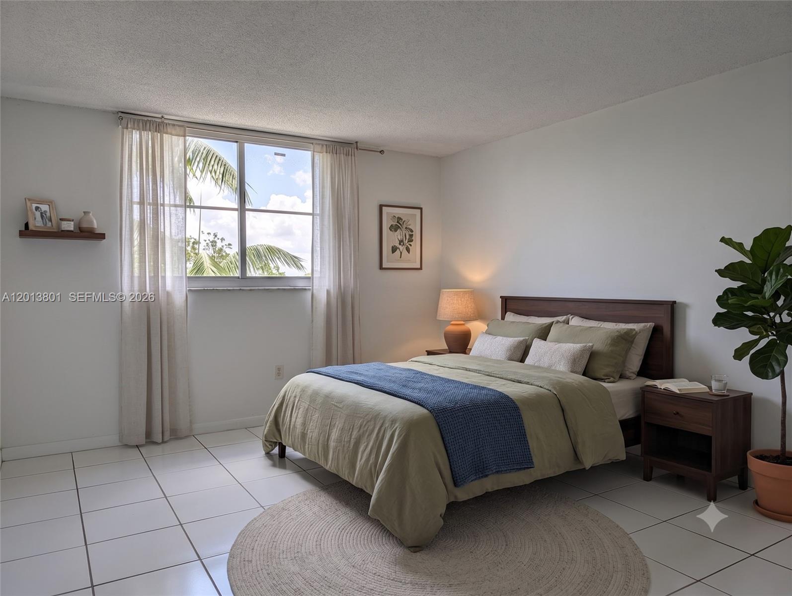 A bedroom features a bed with green bedding, a blue throw, and a potted plant — 210 Sea View Dr # 405, Key Biscayne FL 33149, KEY BISCAYNE, FL