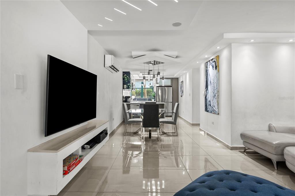 A modern open-concept living and dining area features white walls, tiled floors, and recessed lighting — Carretera 187 Km 23.6 AQUATIKA UNIT 1501, LOIZA, PR