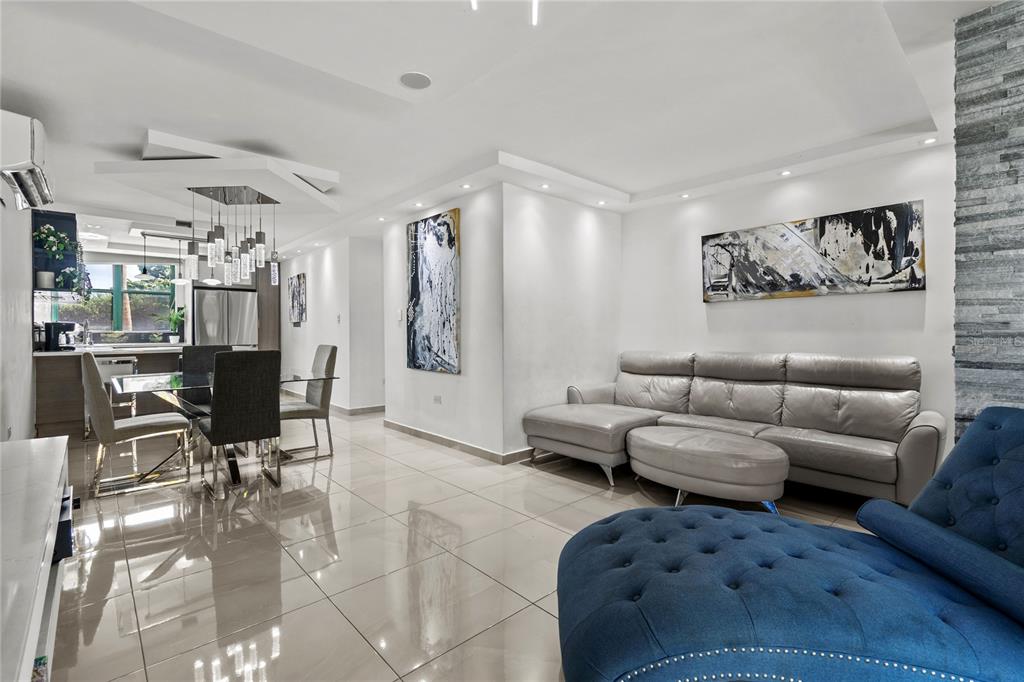 A modern open-concept living and dining area features tile flooring, recessed lighting, and contemporary furniture — Carretera 187 Km 23.6 AQUATIKA UNIT 1501, LOIZA, PR