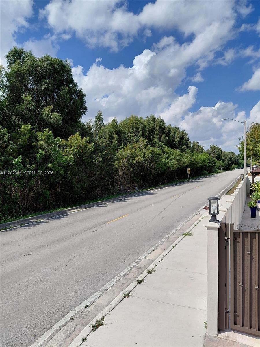 A paved road runs alongside a sidewalk and a dense line of trees — 168xx 45th st, Miami FL 33185, MIAMI, FL