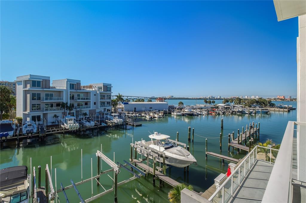 An elevated view of a marina with docked boats, a bridge, and modern waterfront buildings — 920 N OSCEOLA AVENUE UNIT 307, CLEARWATER, FL