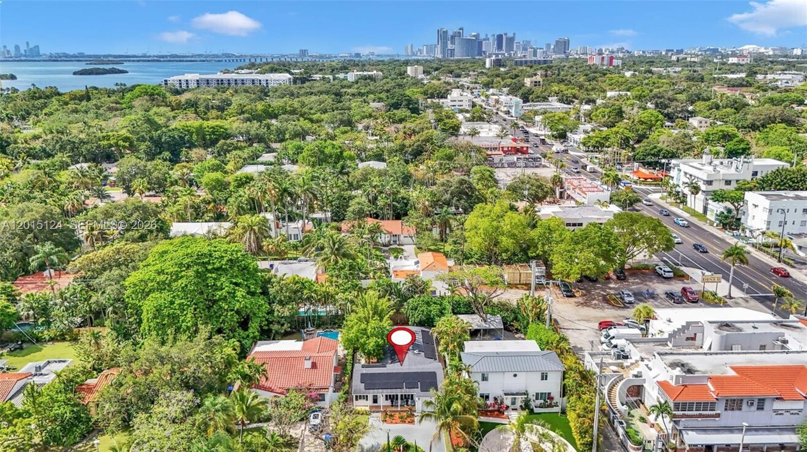 An aerial view shows a residential property with a solar-paneled roof and surrounding lush greenery — 634 NE 72nd Ter, Miami FL 33138, MIAMI, FL