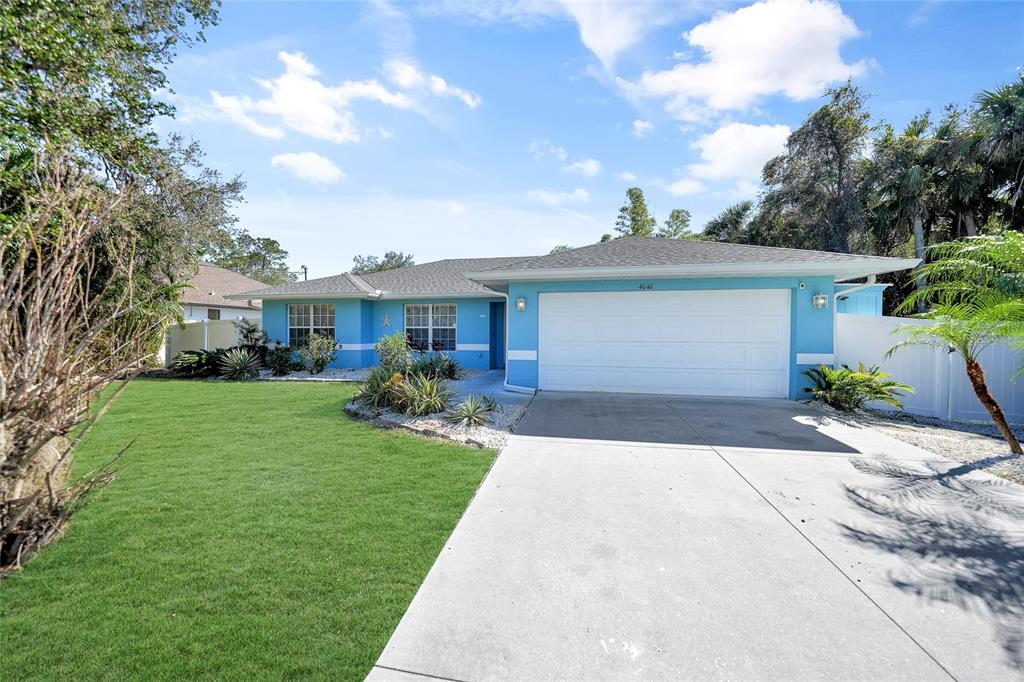 A single-story blue house with a two-car garage and a front lawn — 4040 S CRANBERRY BOULEVARD, NORTH PORT, FL
