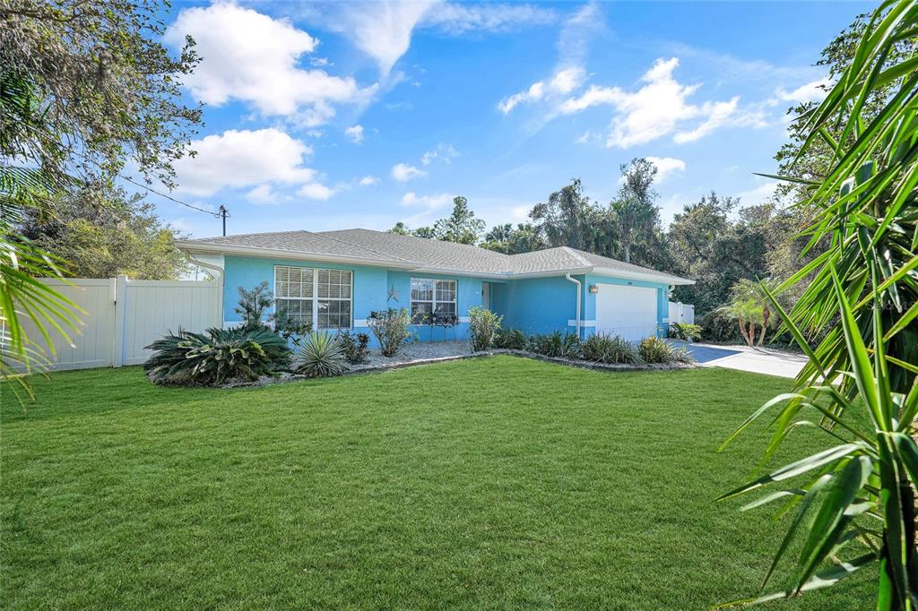 A single-story blue house with a white garage and a green lawn under a sky — 4040 S CRANBERRY BOULEVARD, NORTH PORT, FL