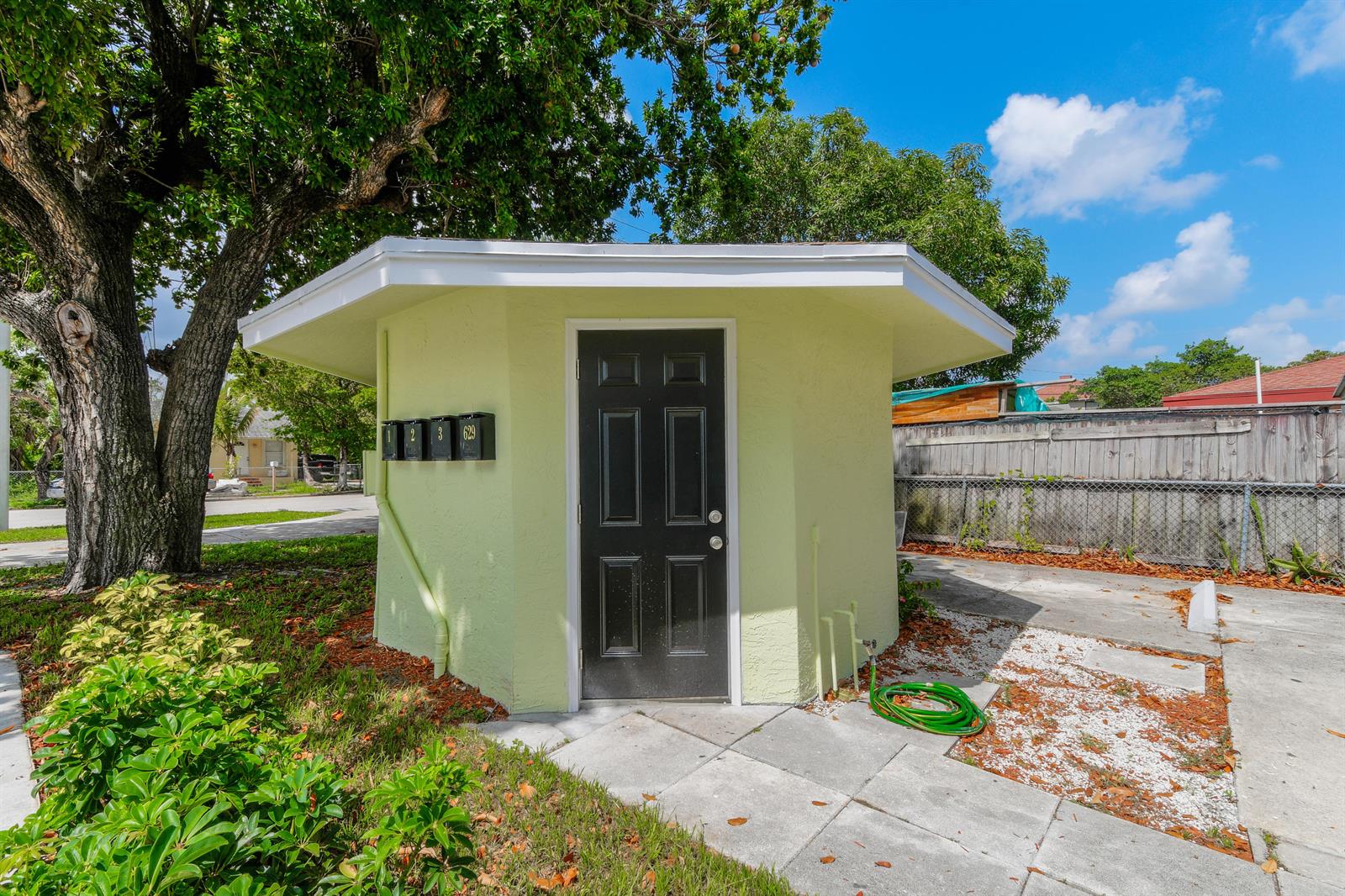 A small, light green, hexagonal utility building with a black door and three mailboxes — 627 Bunker Road, West Palm Beach FL 33405, WEST PALM BEACH, FL
