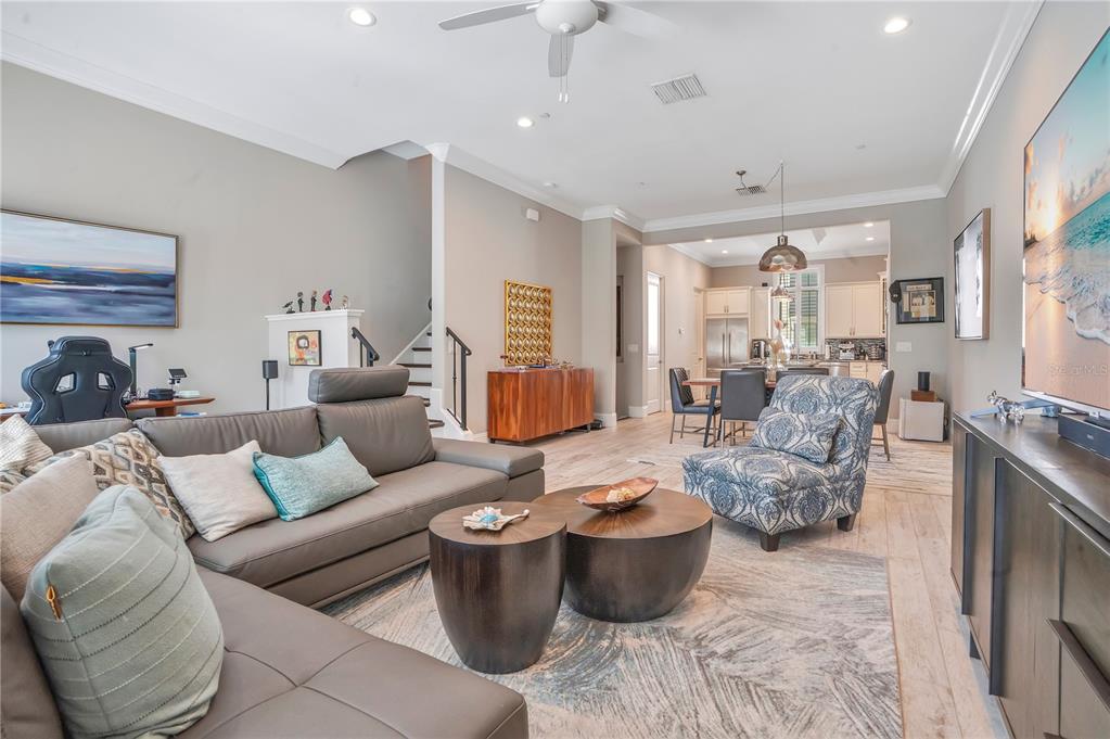 A living room with a grey leather sectional, two round coffee tables, and an open kitchen — 665 JACKSON STREET, ORLANDO, FL
