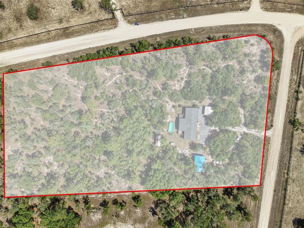 This aerial view shows a house with a pool on a large, wooded lot — 5330 SE 128TH TERRACE, MORRISTON, FL