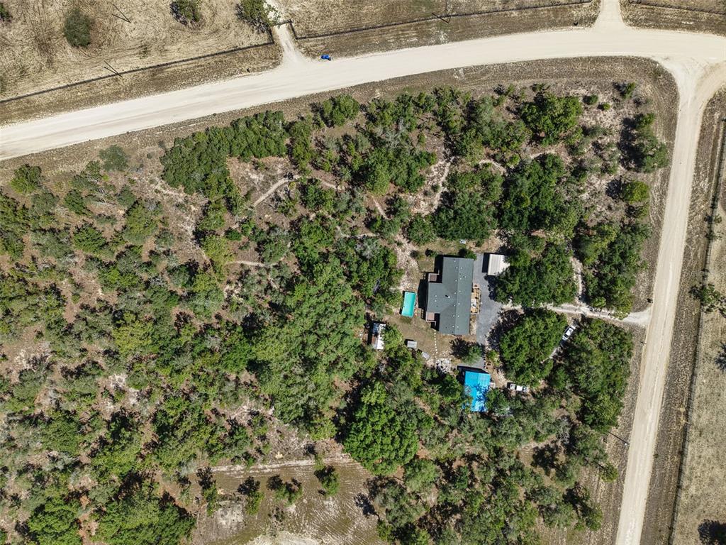 An aerial view shows a house with a pool surrounded by trees on a corner lot — 5330 SE 128TH TERRACE, MORRISTON, FL