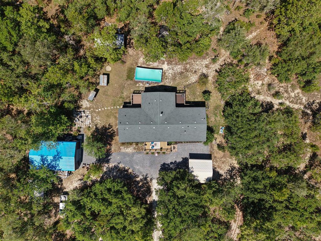 An aerial view shows a house with a pool, a blue-roofed garage, and surrounding trees — 5330 SE 128TH TERRACE, MORRISTON, FL