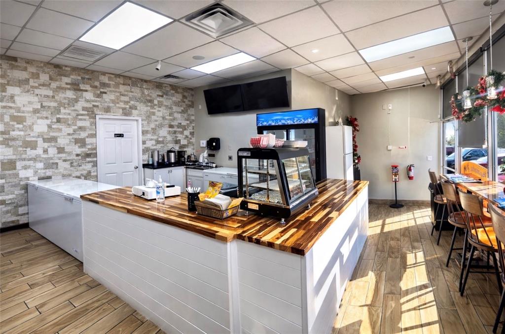 A commercial space features a wooden service counter, stone accent wall, and tiled flooring — 517 N SEMORAN BOULEVARD, ORLANDO, FL