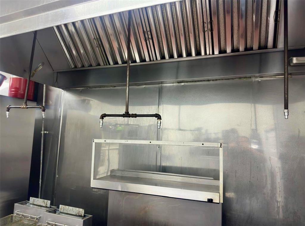 A commercial kitchen hood with stainless steel surfaces and suspended plumbing fixtures — 517 N SEMORAN BOULEVARD, ORLANDO, FL