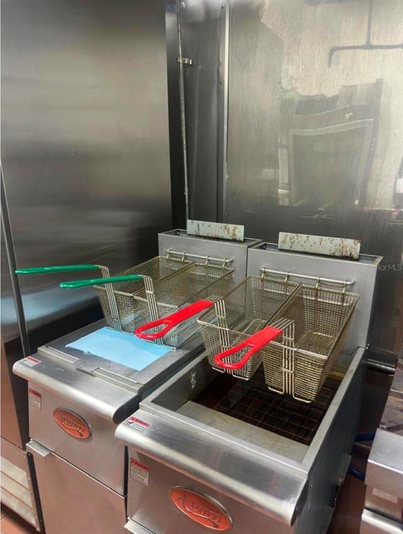 Two stainless steel commercial deep fryers with wire baskets sit in a kitchen — 517 N SEMORAN BOULEVARD, ORLANDO, FL