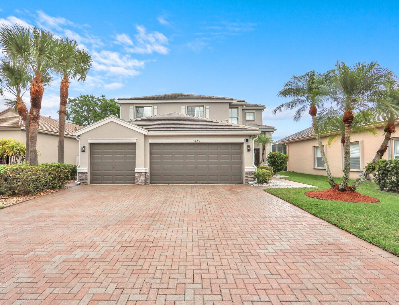 A two-story house with a three-car garage and a brick paver driveway — 5690 Saddle Trail Lane, Lake Worth FL 33449, LAKE WORTH, FL