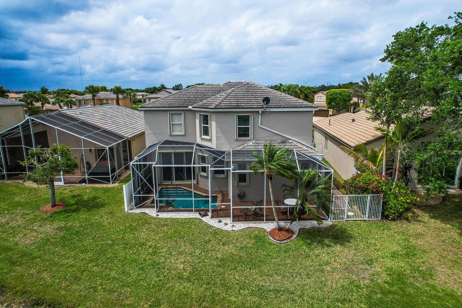 An aerial view of a two-story house with a screened-in pool and patio area — 5690 Saddle Trail Lane, Lake Worth FL 33449, LAKE WORTH, FL