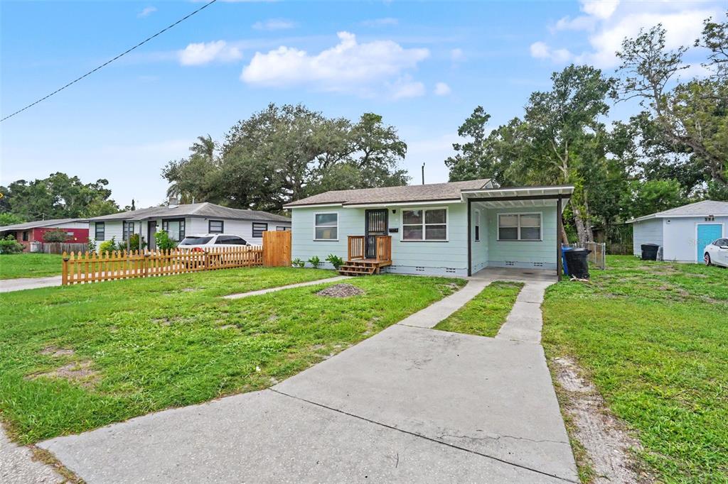 A light green single-story house with a concrete driveway and a small wooden front porch — 2311 35TH STREET S, ST PETERSBURG, FL