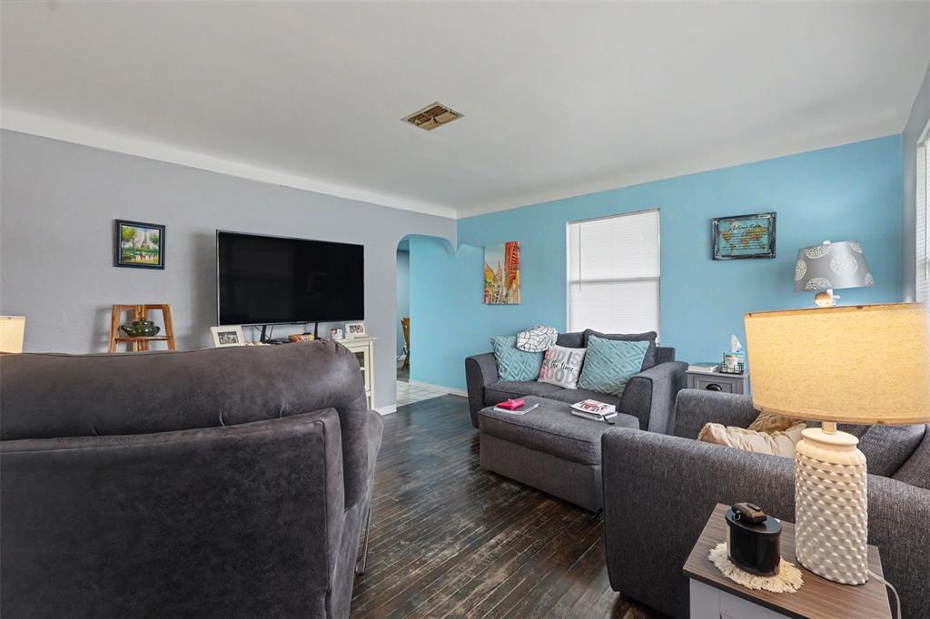 A living room features dark wood floors, gray and blue walls, and gray upholstered furniture — 2311 35TH STREET S, ST PETERSBURG, FL