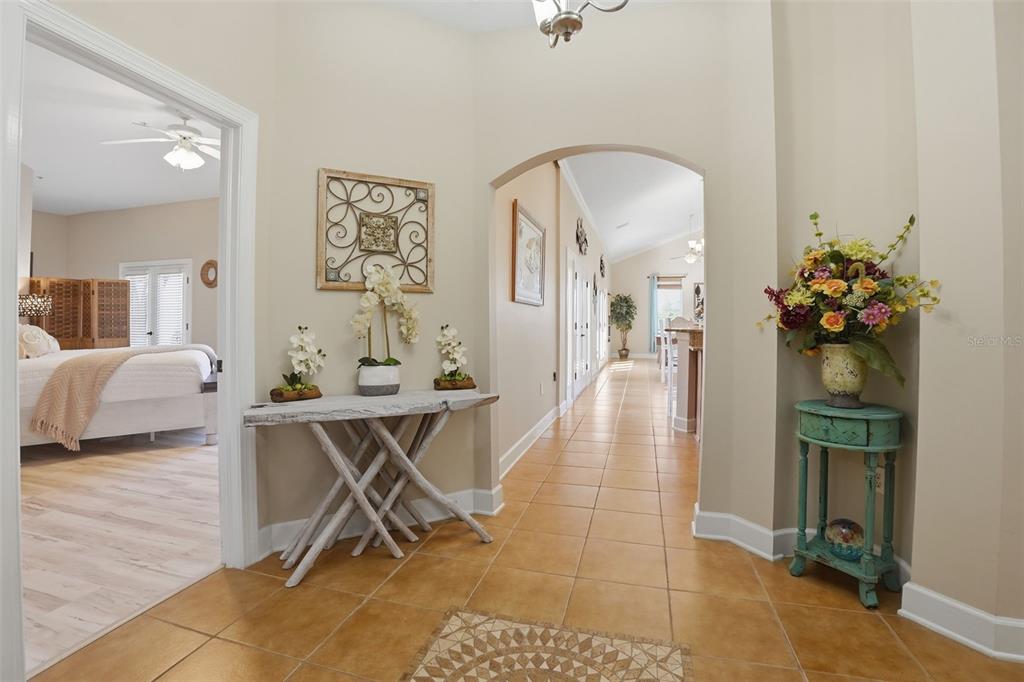 A tiled foyer features a rustic console table, an arched hallway, and a bedroom entrance — 200 BELLA HARBOR COURT UNIT 113, PALM COAST, FL
