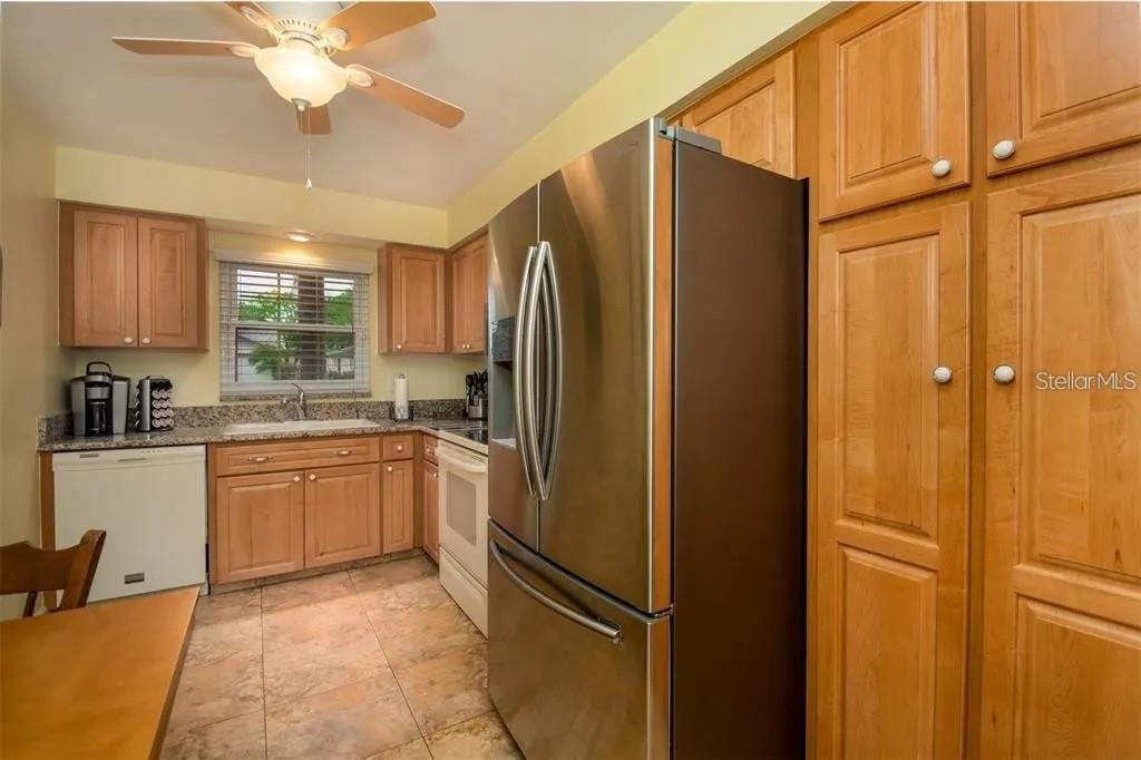 A kitchen with light wood cabinets, stainless steel appliances, and tile flooring — 999 GILLESPIE DRIVE, PALM HARBOR, FL
