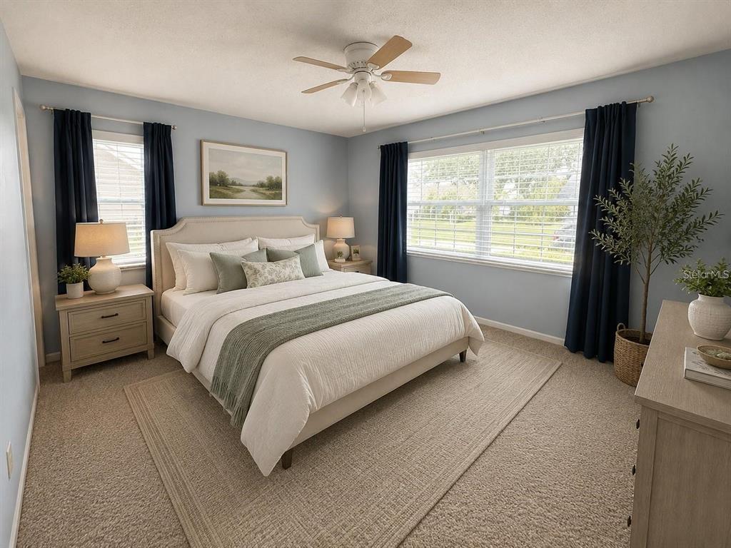 A bedroom features a bed with light bedding, blue walls, dark curtains, and a ceiling fan — 999 GILLESPIE DRIVE, PALM HARBOR, FL