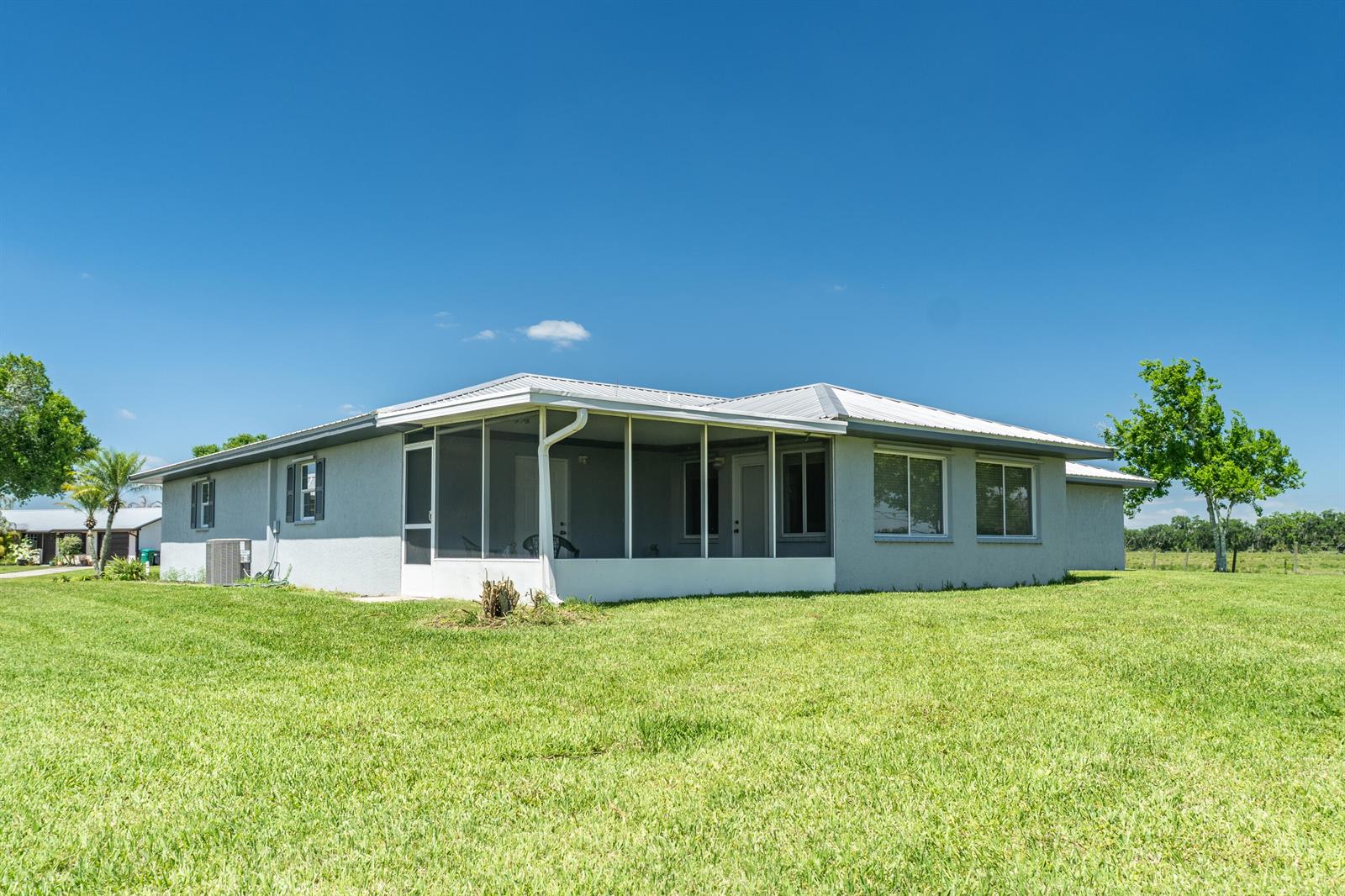 A light gray house with a metal roof and a screened-in back porch — 5264 SE 42nd Street, Okeechobee FL 34974, OKEECHOBEE, FL